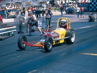 Ignore the NHRA-mandated double-hoop rollbar and it's 1960 all over again as this triple-deuced, flathead-powered rail makes an exhibition pass. These are cheap and easy to build.