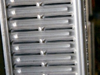 Tubes in all radiators are flattened to increase surface area that contacts the fins. Aluminum radiators use 1-inch-diameter tubes like this cutaway from Afco. American-made radiators such as this one also use thicker wall tubes that are less likely to fail under high pressure.
