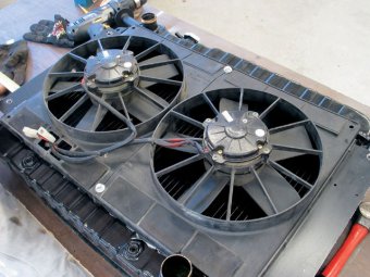 Twin fans can be a plus in tight-clearance situations, since staggering the two fans moves them away from the water-pump pulley. This is a twin Spal-fan setup that incorporates small rubber flaps that open at higher vehicle speeds to improve airflow.